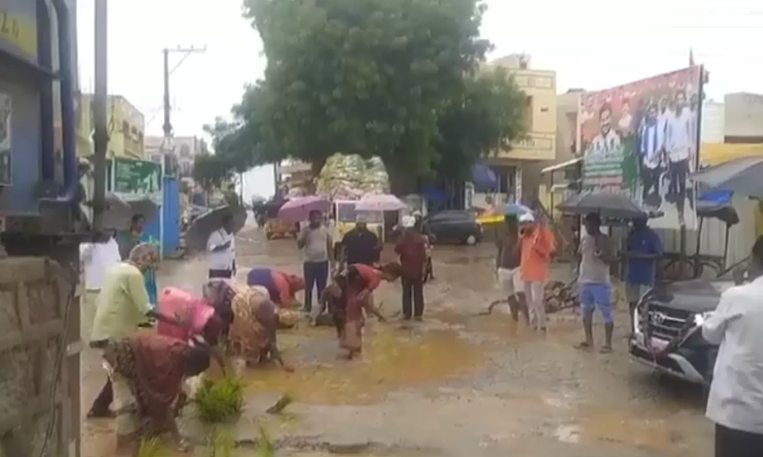 Women protest poor road conditions by planting rice saplings in potholes in Bowrampet